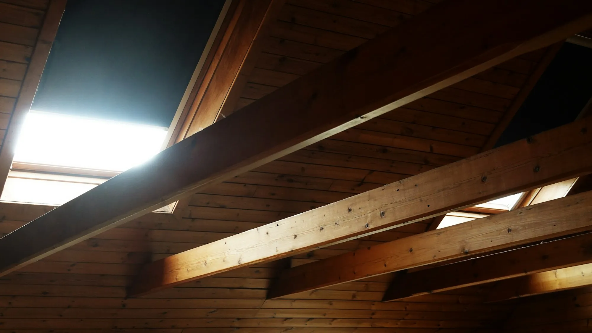 Ungenutzter Dachraum mit offenen Sparren und einem Dachfenster